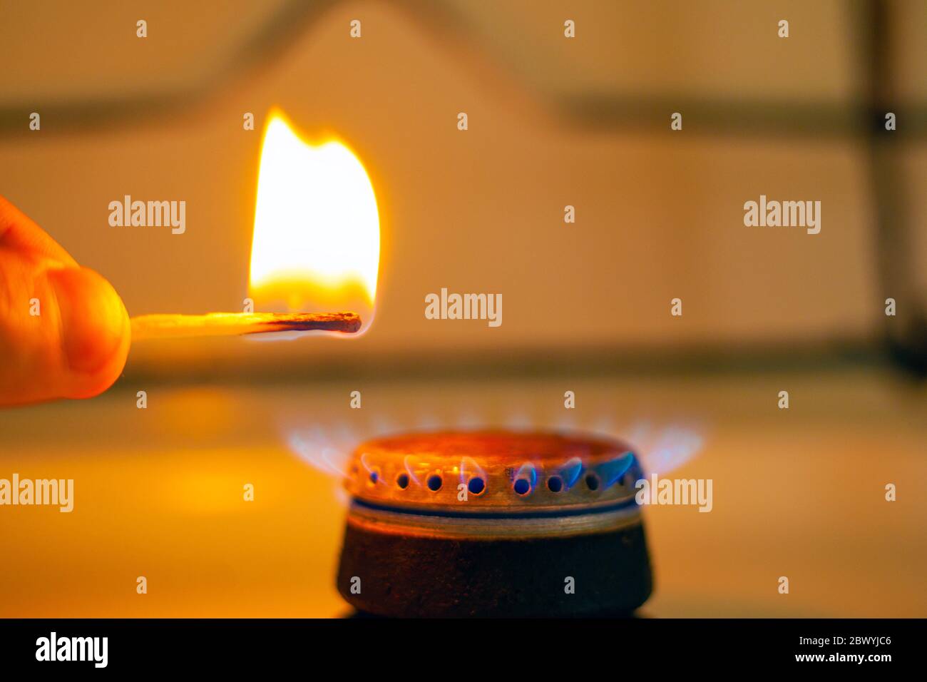 man lights a gas stove with a match closeup. gas stove with burning