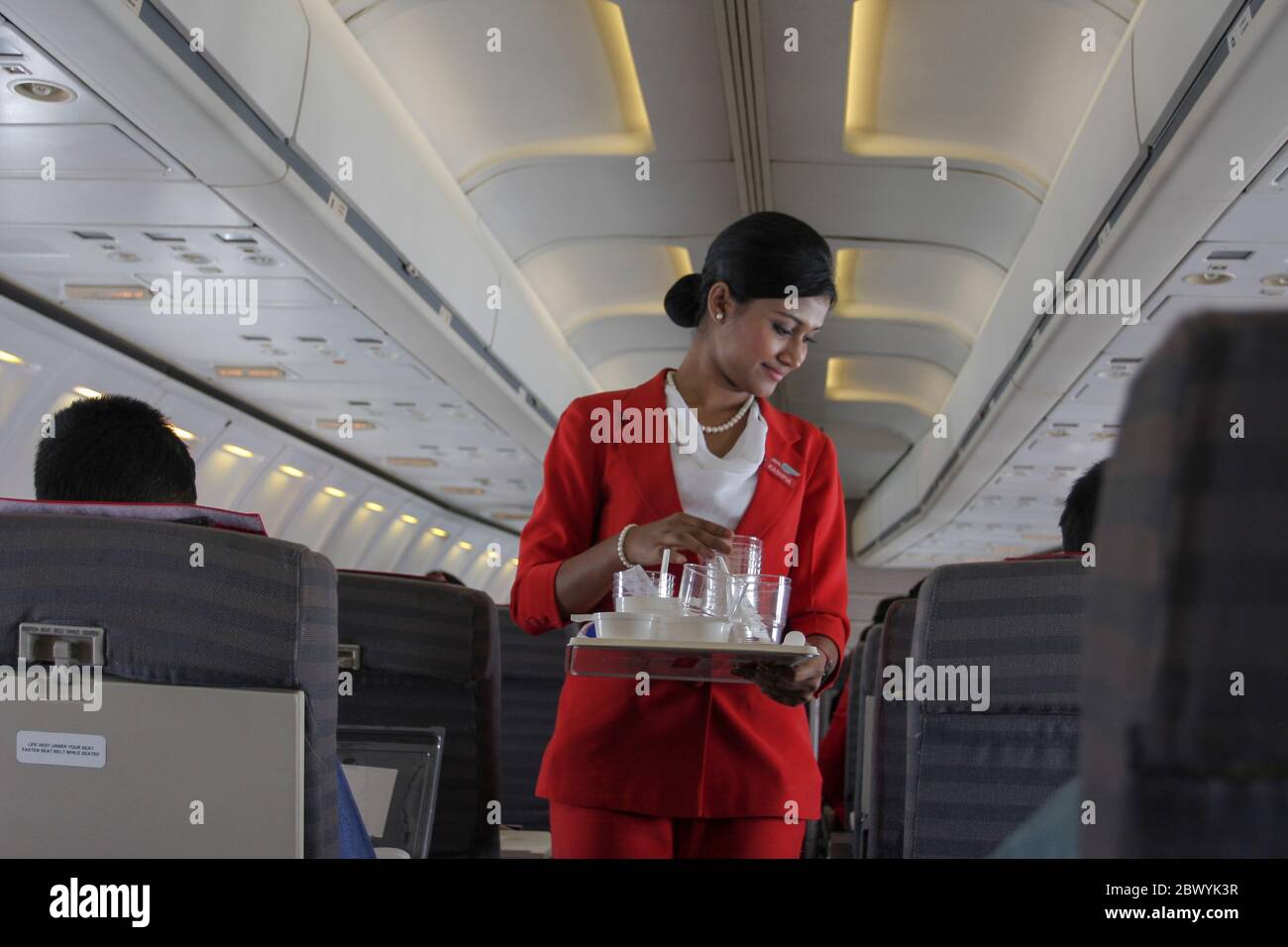 A cabin crew collecting used water glass on a Best Airways airplane.  Bangladesh Stock Photo - Alamy