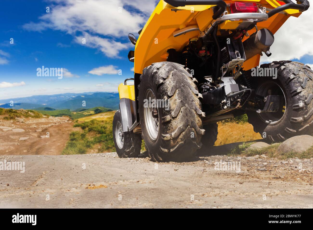 Atv Rear View Photo of a yellow offroad touring atv vehicle standing on a mountain ...