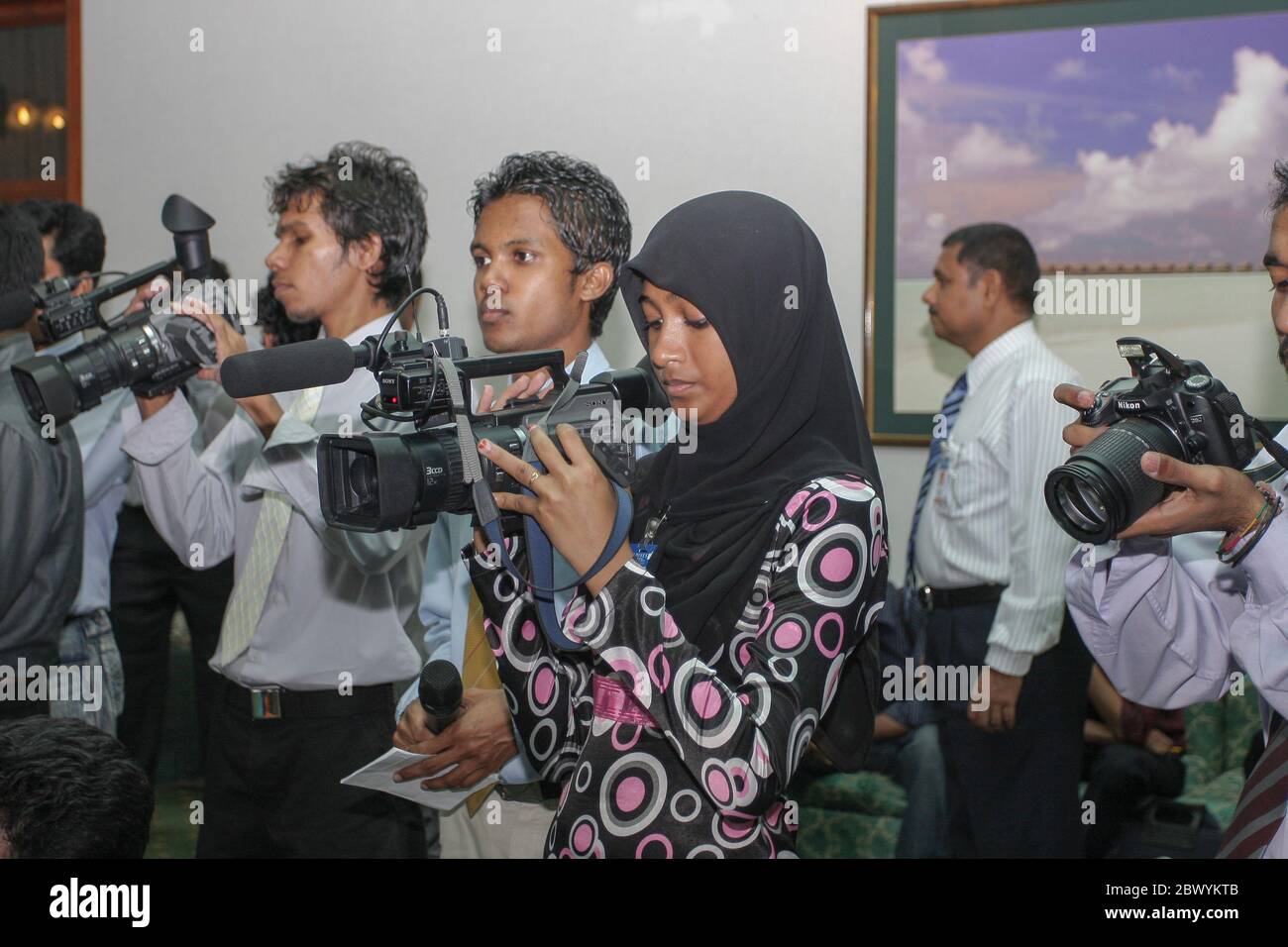 Maldivian news cameraperson at a press conference at Male International Airport, Maldives. Stock Photo