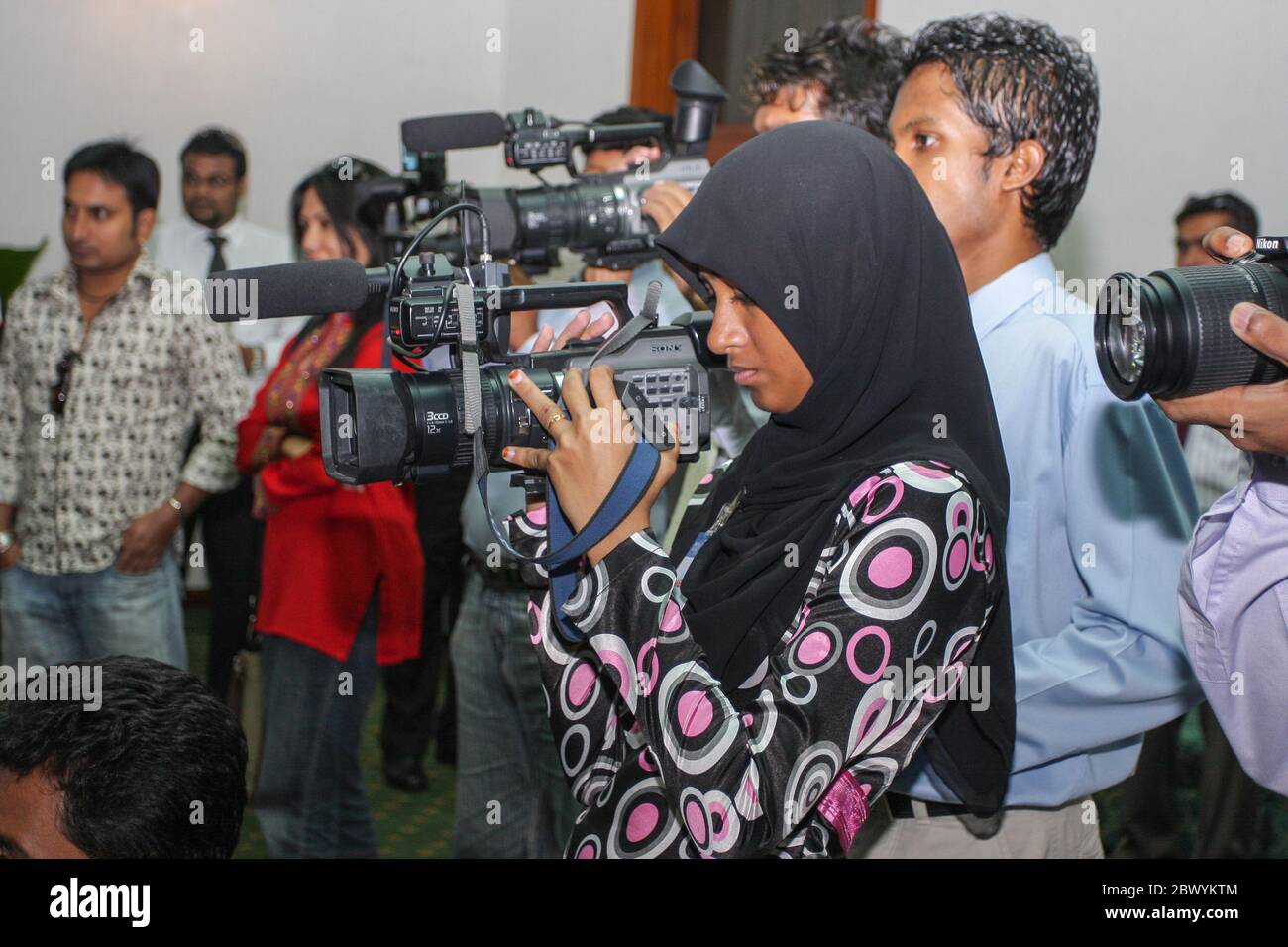 Maldivian news cameraperson at a press conference at Male International Airport, Maldives. Stock Photo