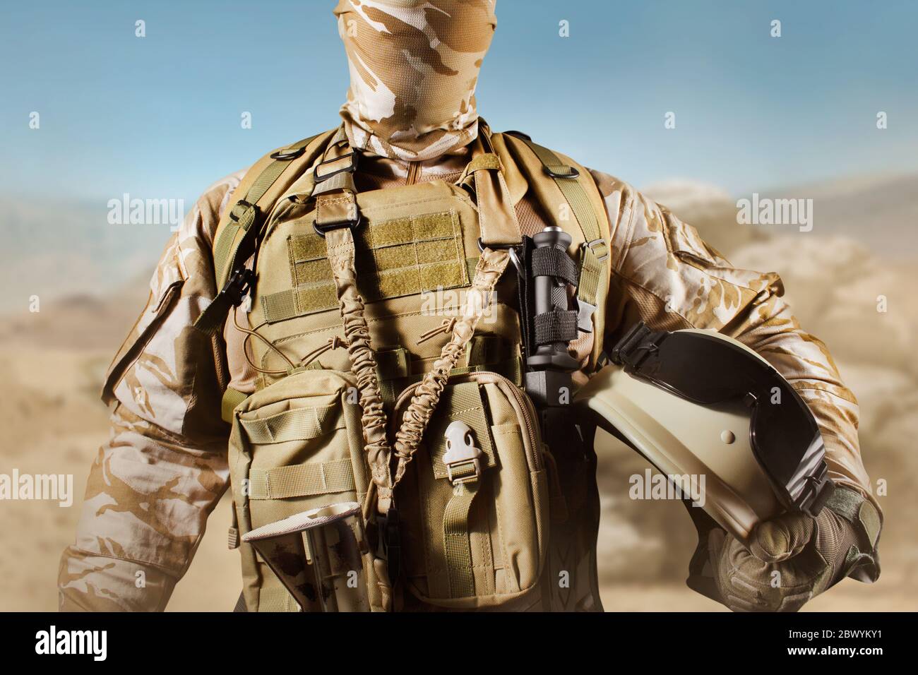 Photo of a fully equipped soldier in uniform, armor standing in desert