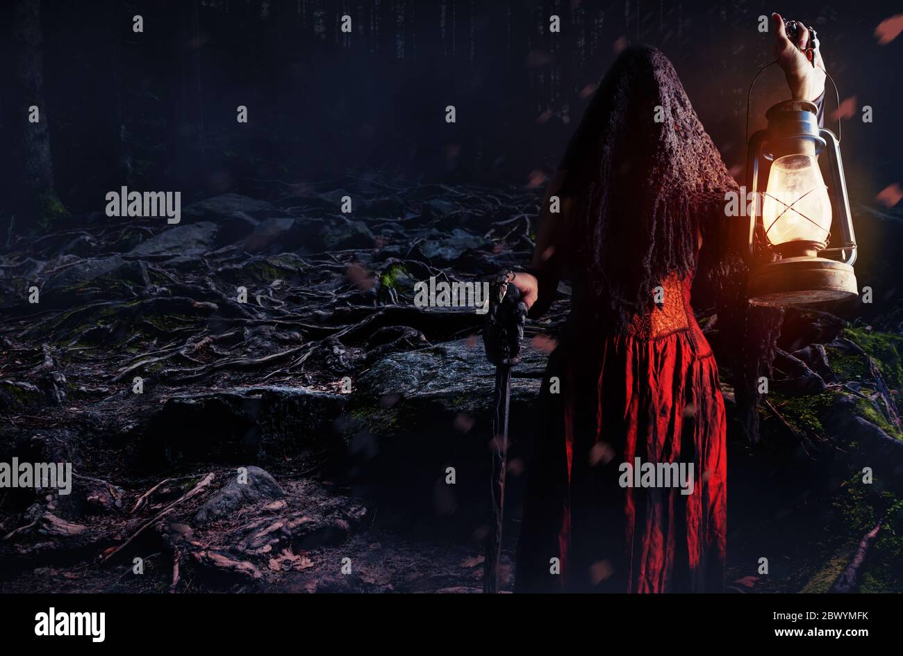 Wide angle photo of a female witch holding lantern and cane in dark ...
