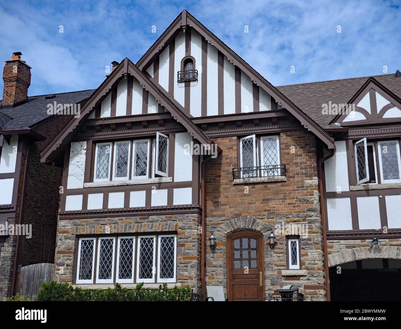 Facade of older Tudor design home with half timbered decorations and leaded glass windows Stock Photo