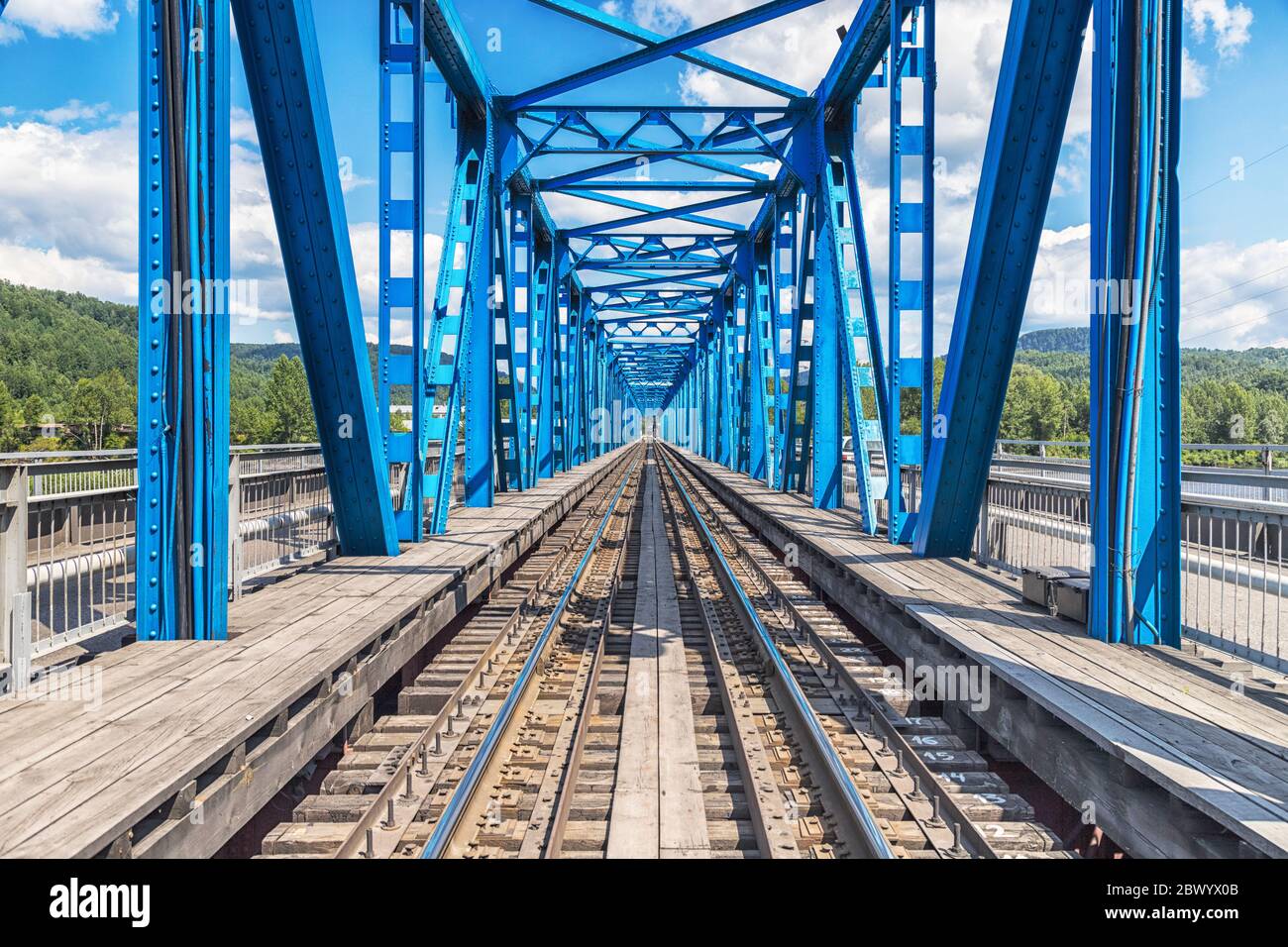 View through blue railway bridge across the river, industrial landscape Stock Photo