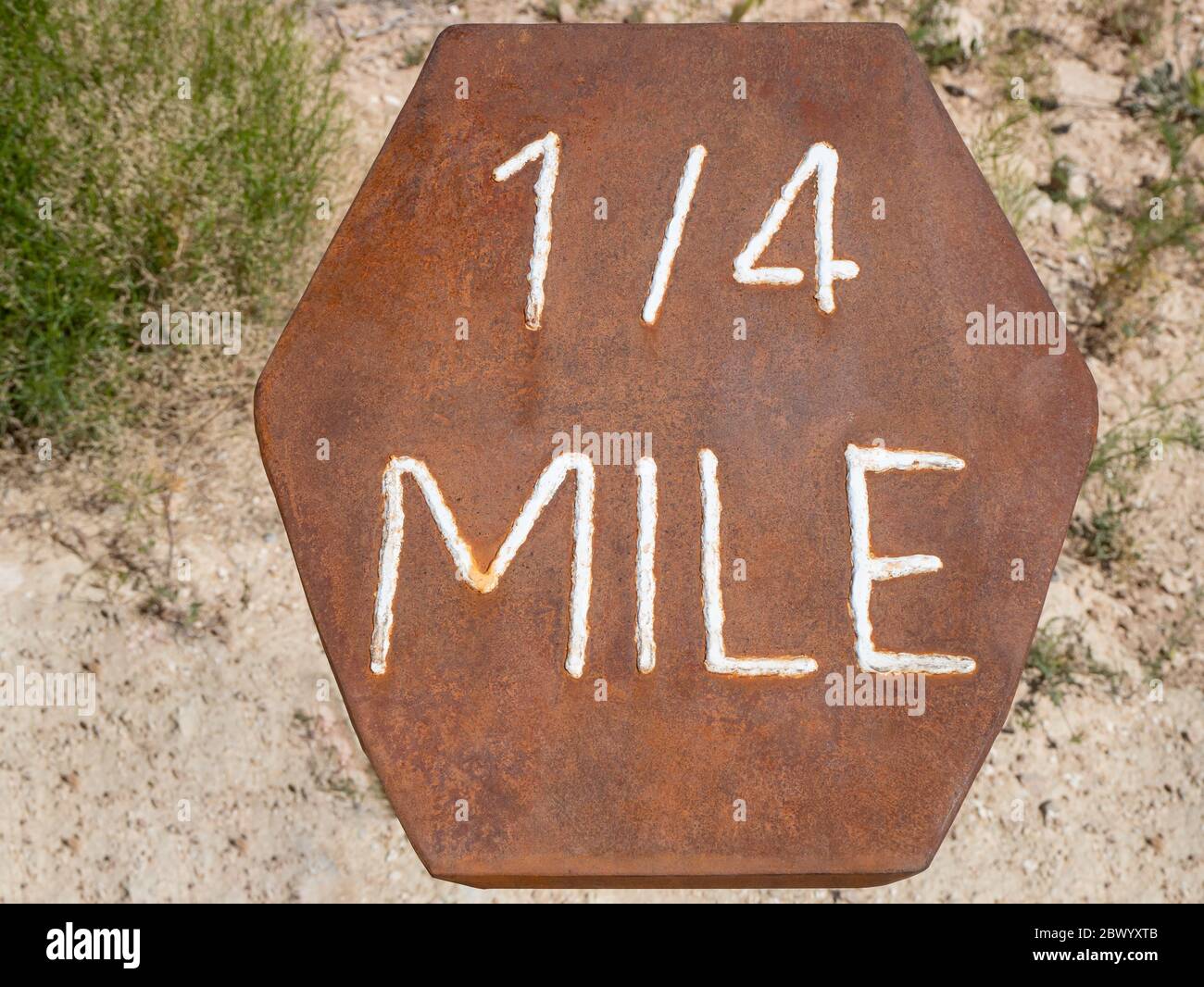 Rusted hexagon shaped hiking trail mile marker Stock Photo