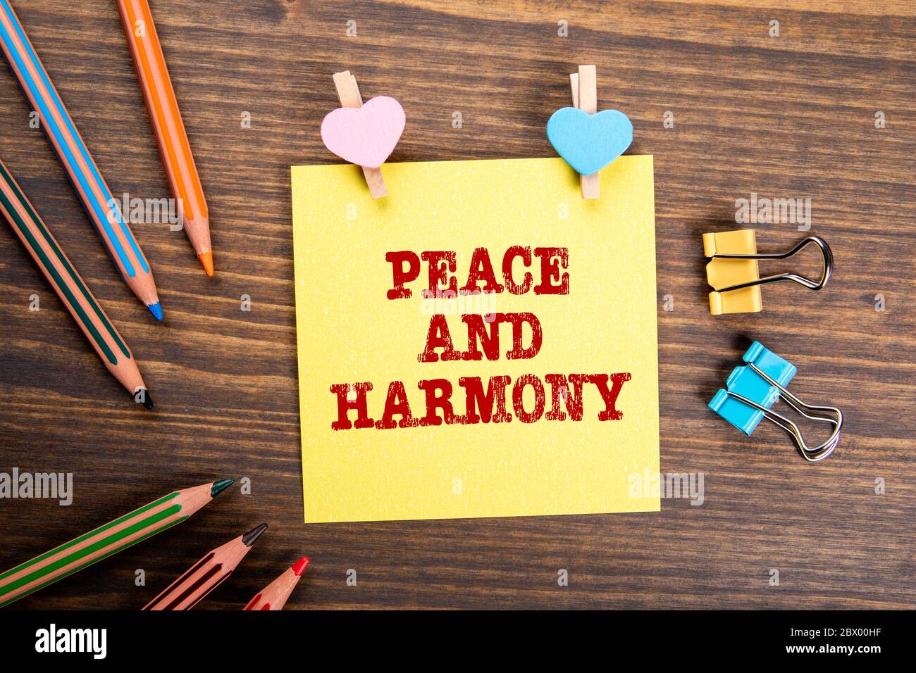 PEACE AND HARMONY. Communication, compromises, ethics and empathy concept. Wooden clips with heart and note on wooden table Stock Photo