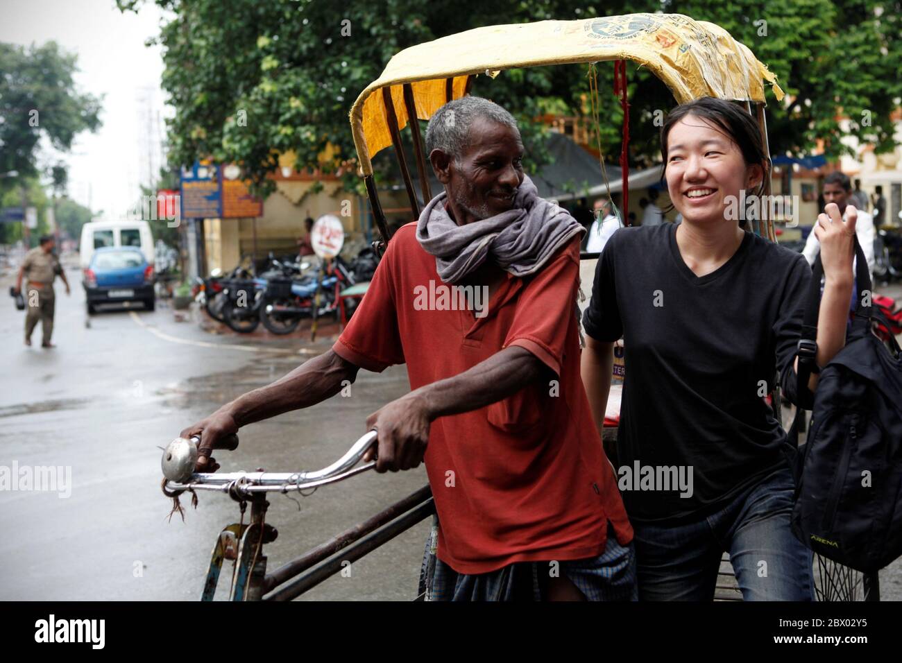 A South Korean-native voluntary worker having short conversation with a rickshaw driver in Bihar province, India. Radha, a given name she preferred to be called with, was working voluntarily in Sujata Technical School run by Joint Together Society (JTS), a relief organization, in Dungeshwari village, Bihar, India. She came from Seoul eight months before, helping on accounting. Stock Photo
