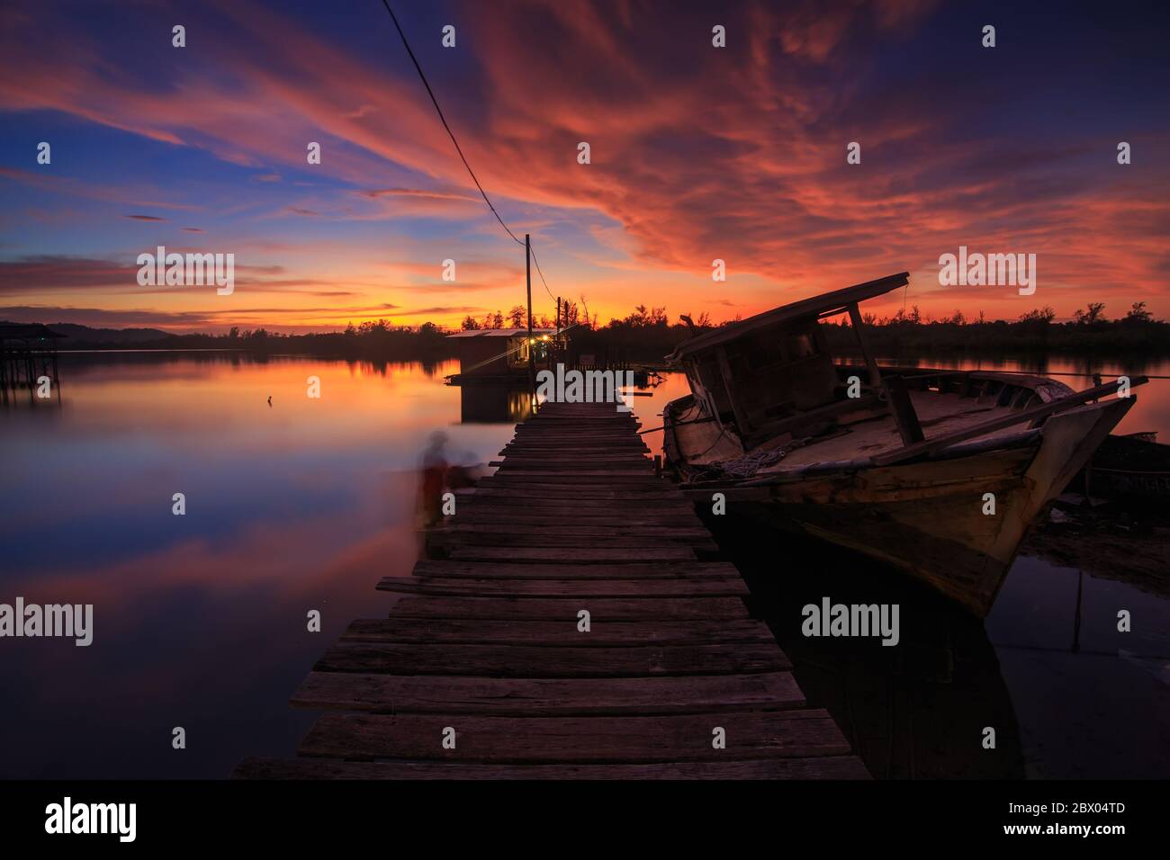 Amazing Sunset Twilight with wooden jetty and Abandon Old wreck on the shore - Landscape concept Stock Photo