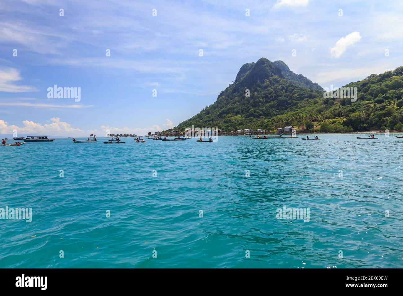 Amazing landscape view of old sea gypsy house in Semporna, Sabah with blue sky background and crystal clear water sea - Travel Concept Stock Photo