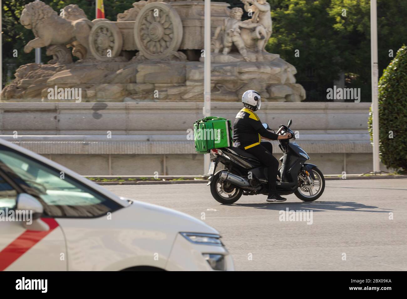 Madrid, Spain - May 19, 2020: Delivery people from the home delivery company, Uber Eats, working on the streets of Madrid, delivering food at rush hou Stock Photo