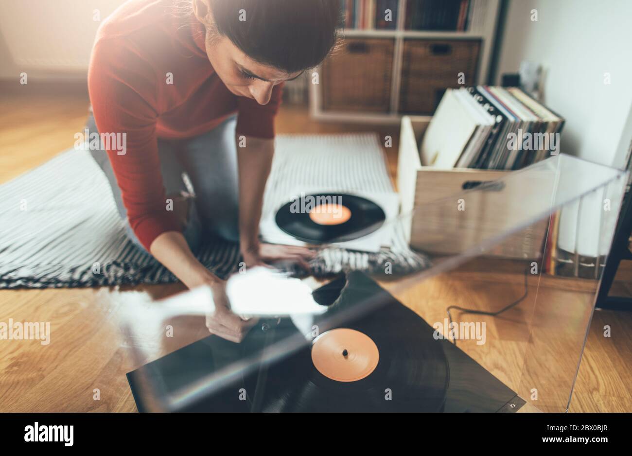 Young woman moving turntable tonearm over favorite song Stock Photo