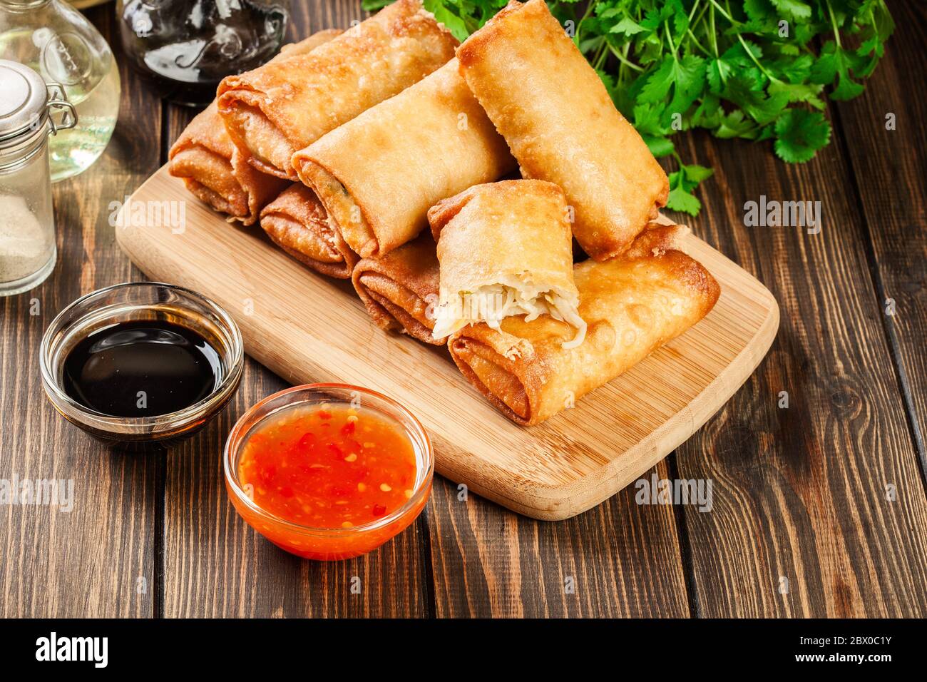 Spring rolls with chicken and vegetables on chopping board. Asian cuisine. Stock Photo
