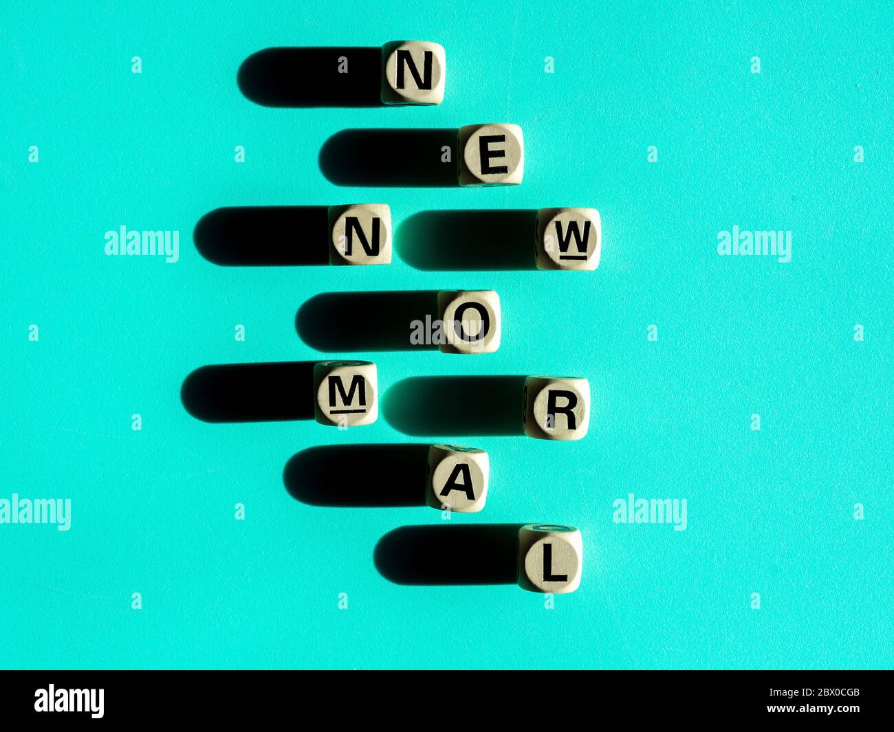 NEW NORMAL, word on wooden alphabet cube on light green background, top ...