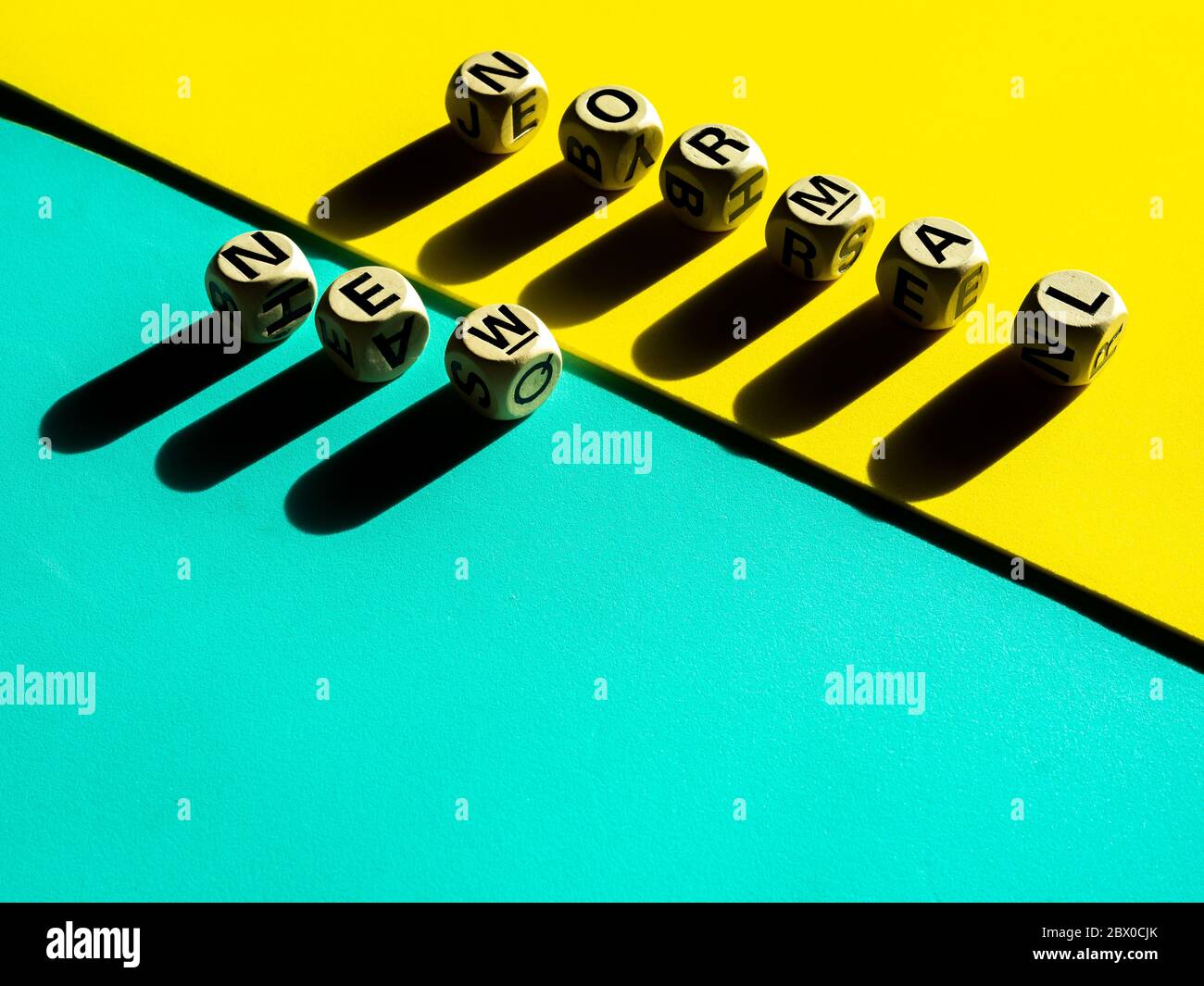 NEW NORMAL, word on wooden alphabet cube on light green and yellow ...