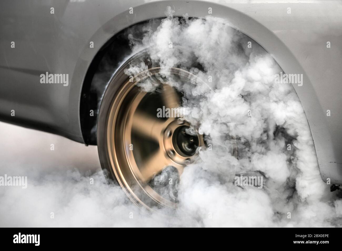 Drag racing car burn tire at starting line in preparation for the race
