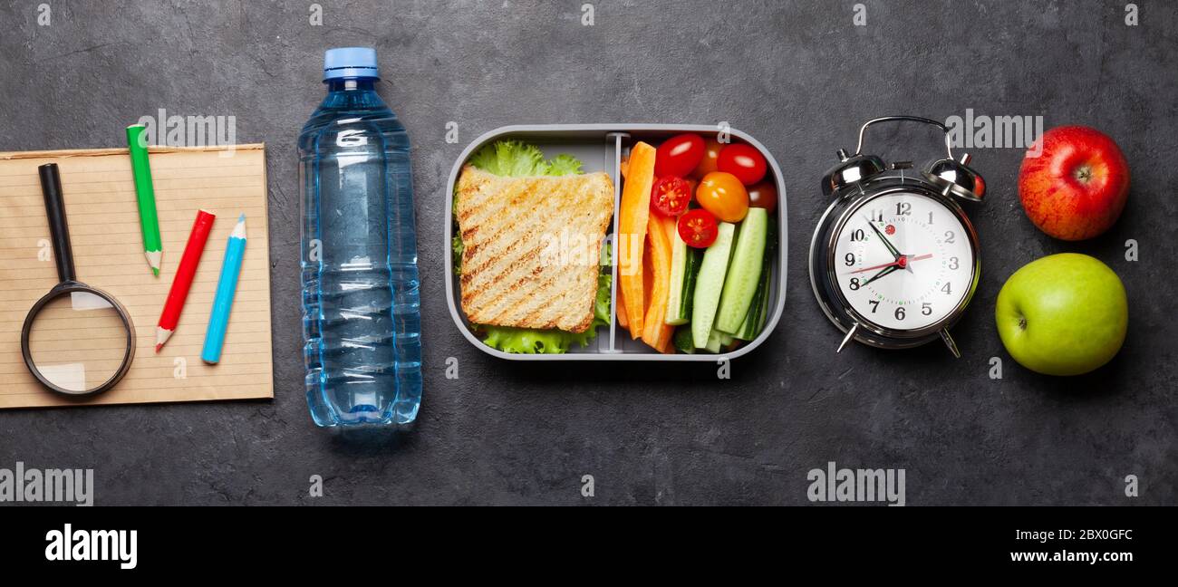 School lunch box and education stationery on stone table. Top view ...