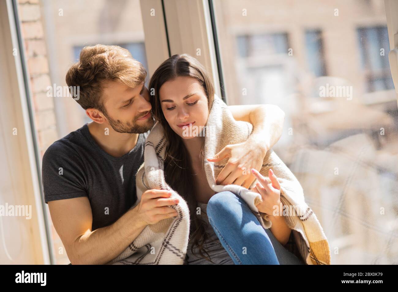 Young bearded man hugging his wife and looking contented Stock Photo ...