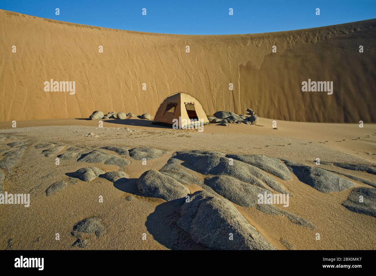 Camping in the lee of a huge sand dune. Four wheel drive desert safari on the Skeleton Coast of Namibia, south west Africa. Stock Photo