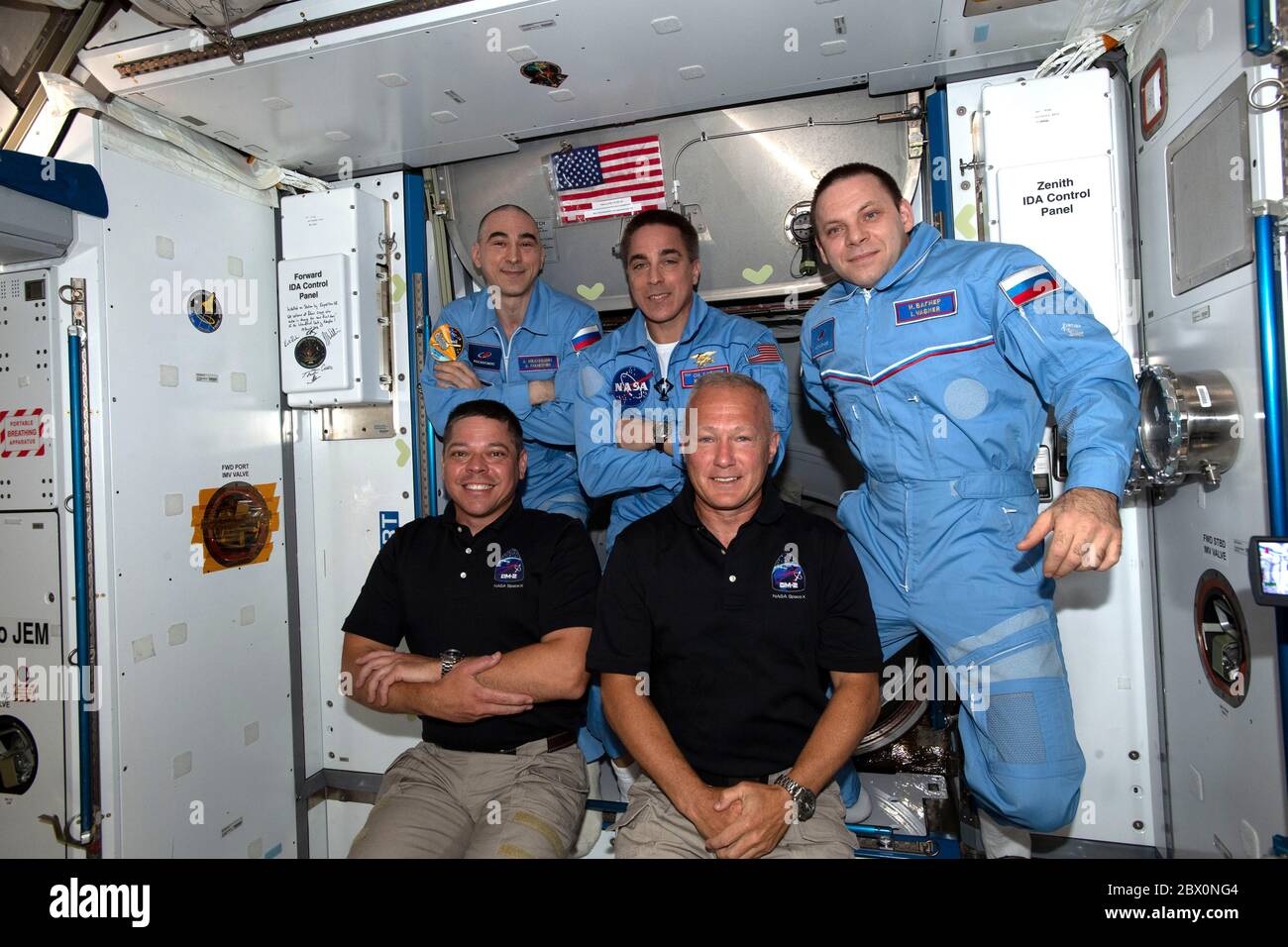 ISS - 31 May 2020 - The newly-expanded Expedition 63 crew with NASA astronauts (front row, from left) Bob Behnken and Doug Hurley having just entered Stock Photo