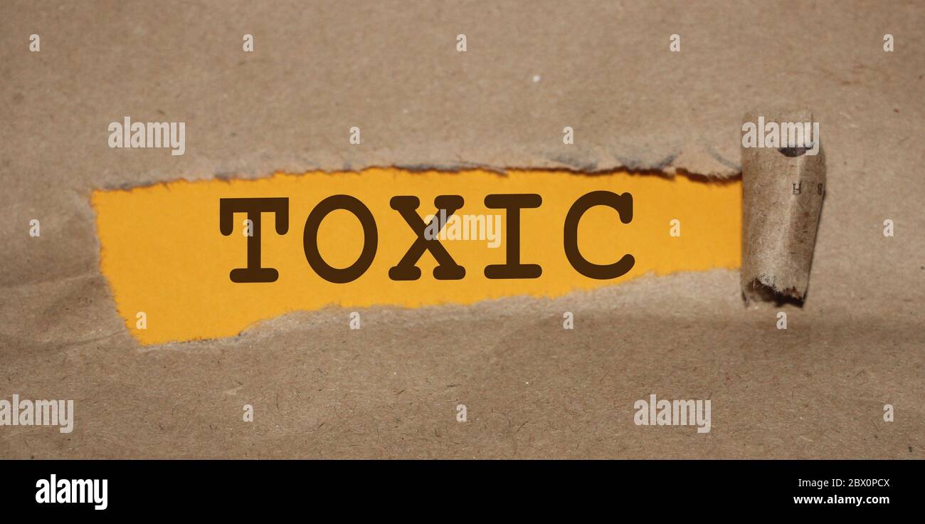 Toxic word uner Brown torn paper with yellow background. Addictions, quit smoking and drinking
