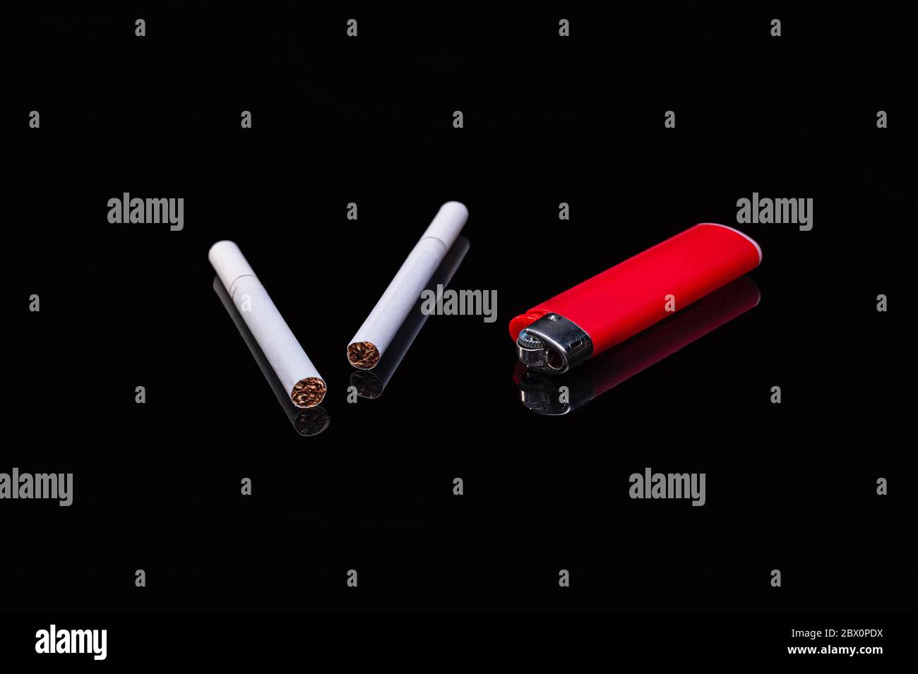 two white filter cigarettes and a plastic gas red lighter on an