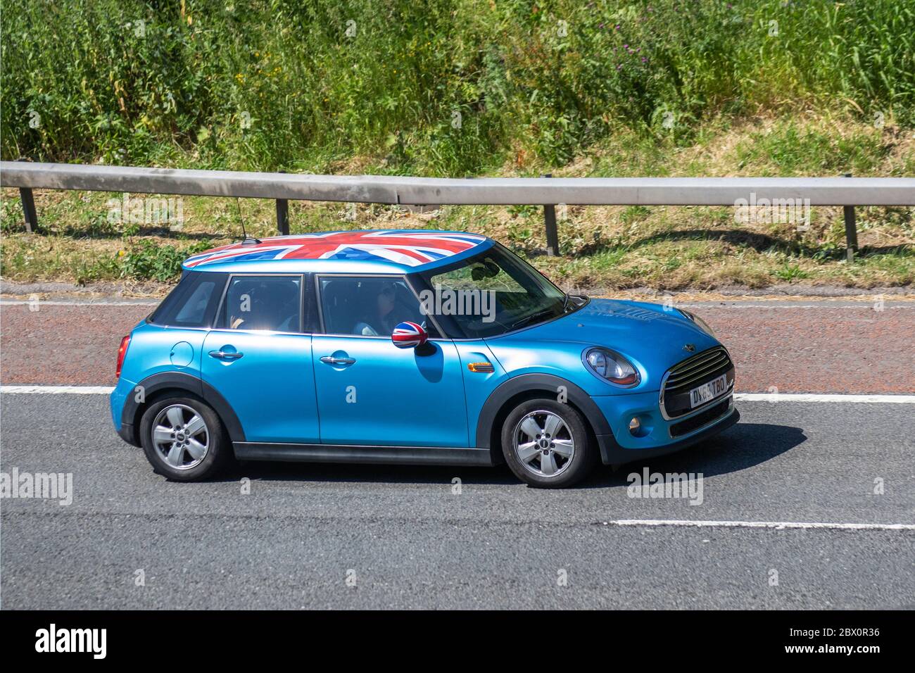 A Red Mini Cooper wth a Union Jack Roof by John Cooper version of the mini  parked on a cobbled street in Huddersfield Stock Photo - Alamy
