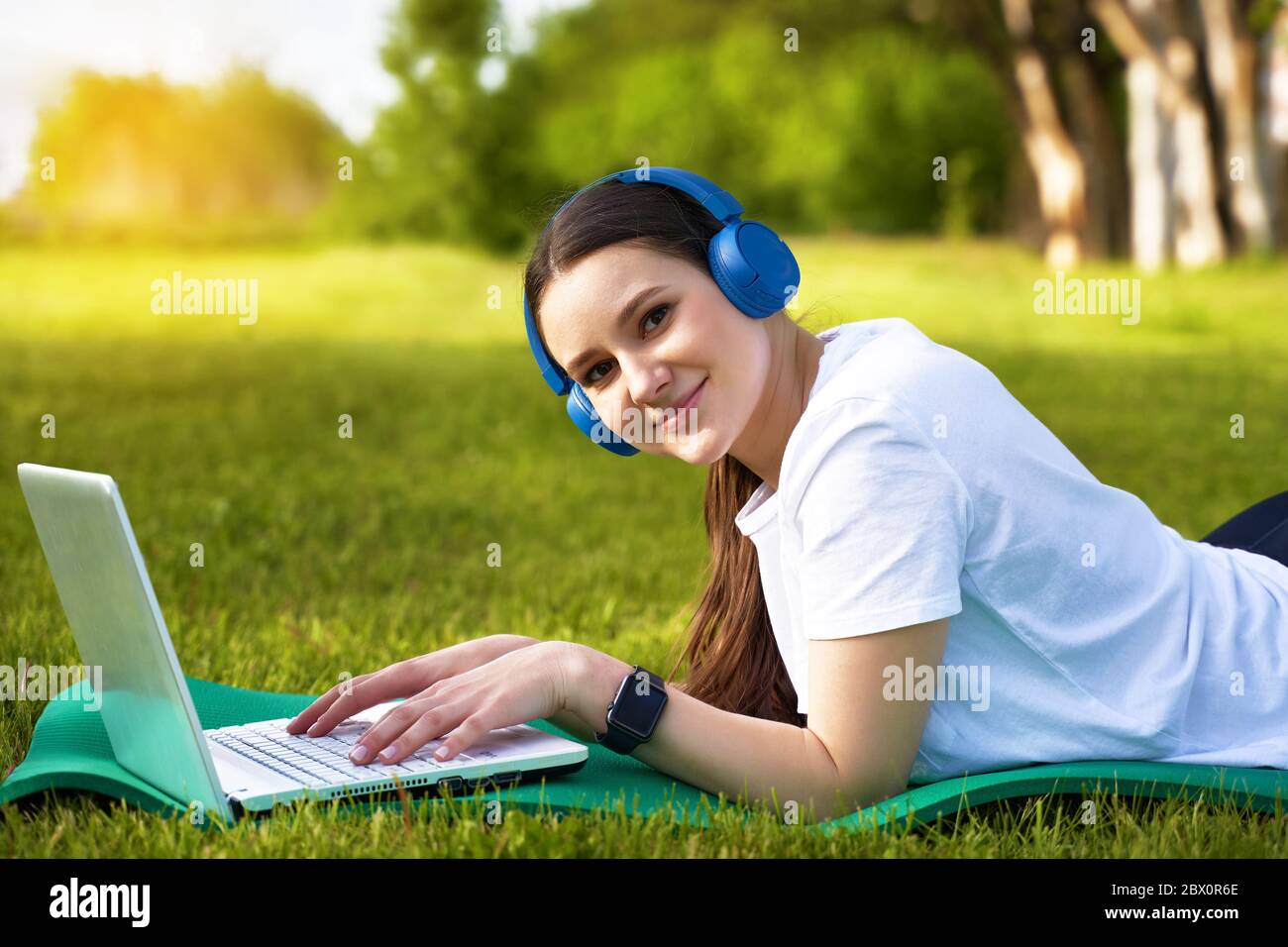 athletic healthy girl in the headphones working in nature Stock Photo