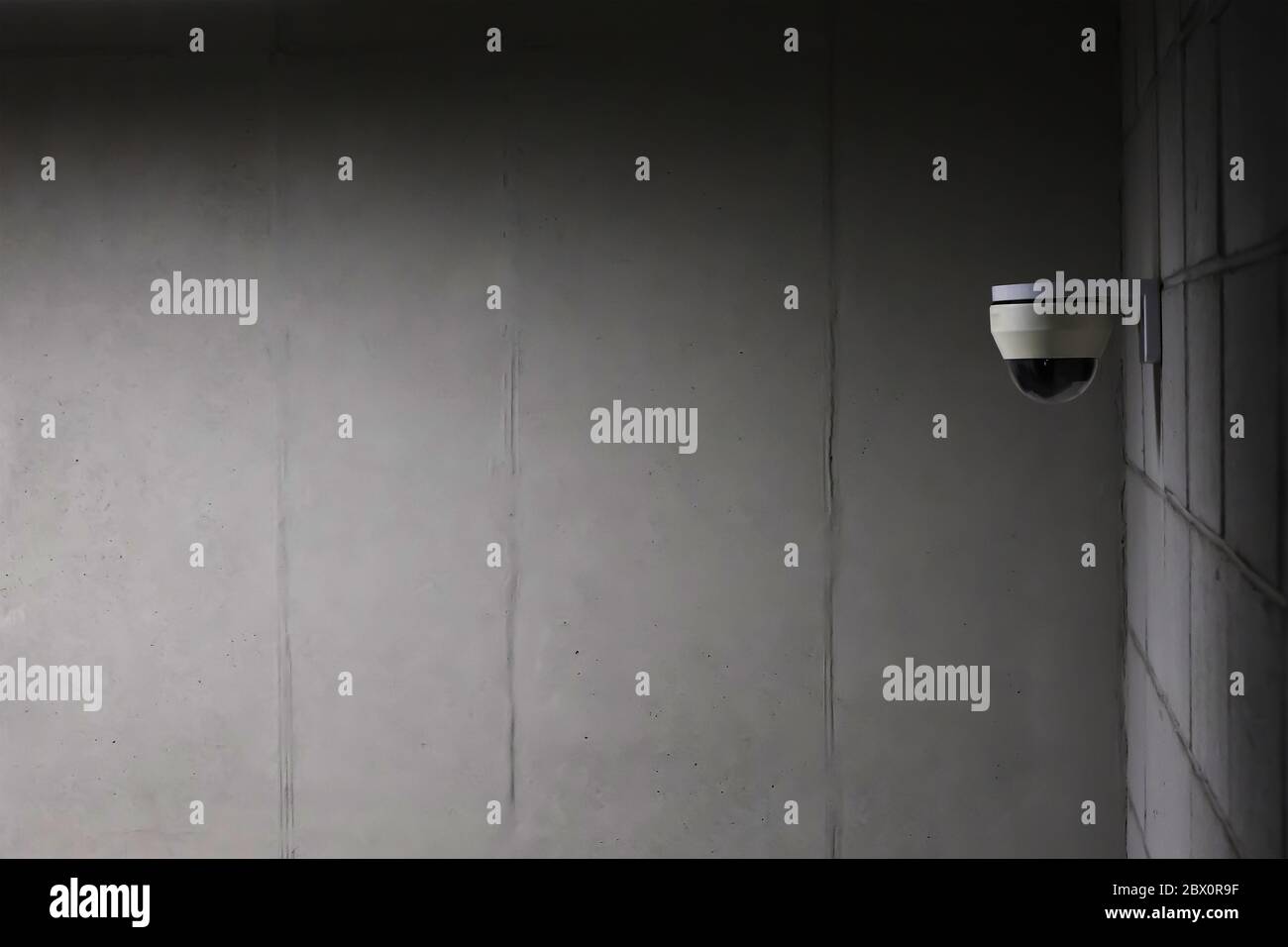 a security camera installed on a concrete wall. Stock Photo