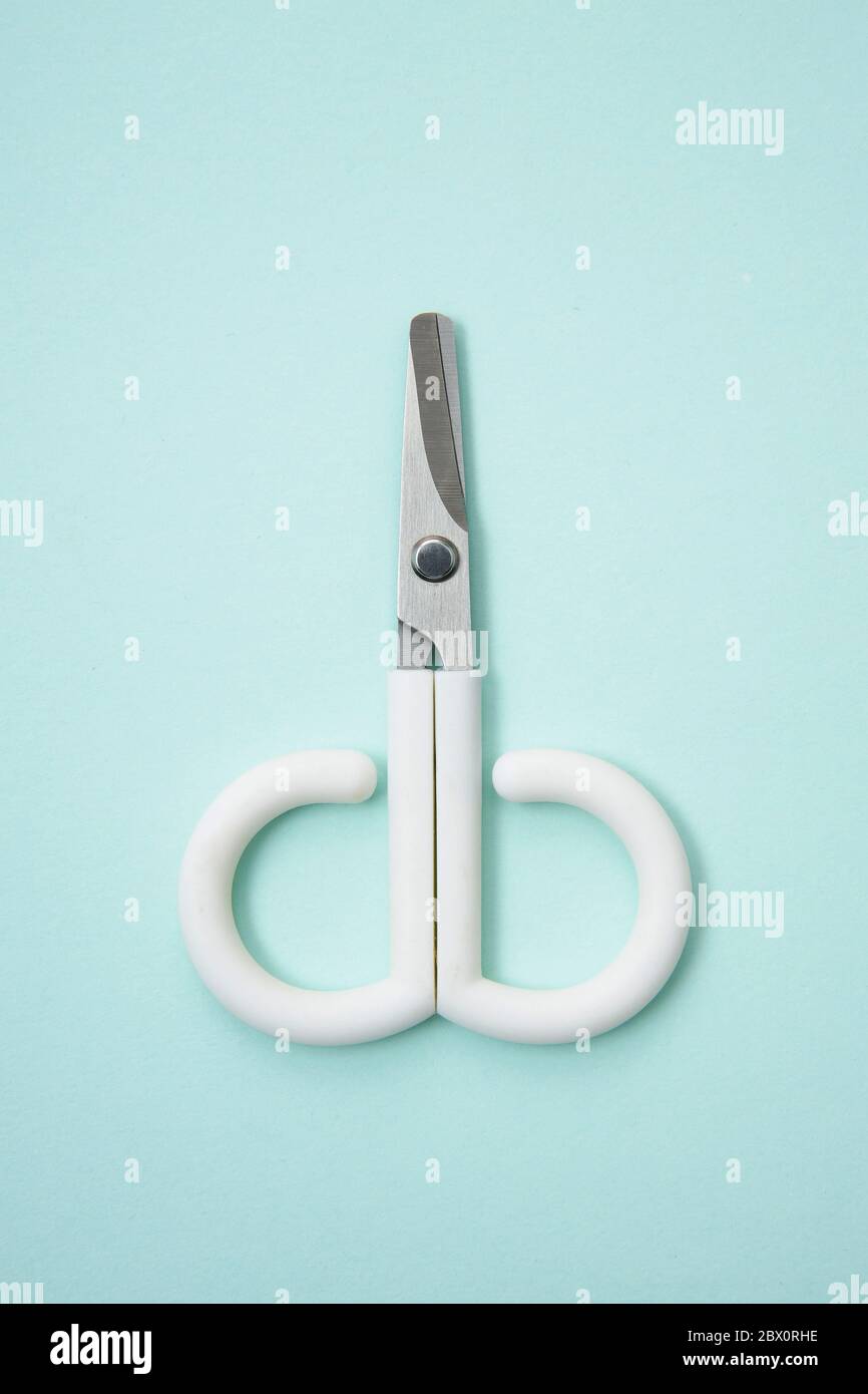 Little cute scissors on a light blue background Stock Photo - Alamy