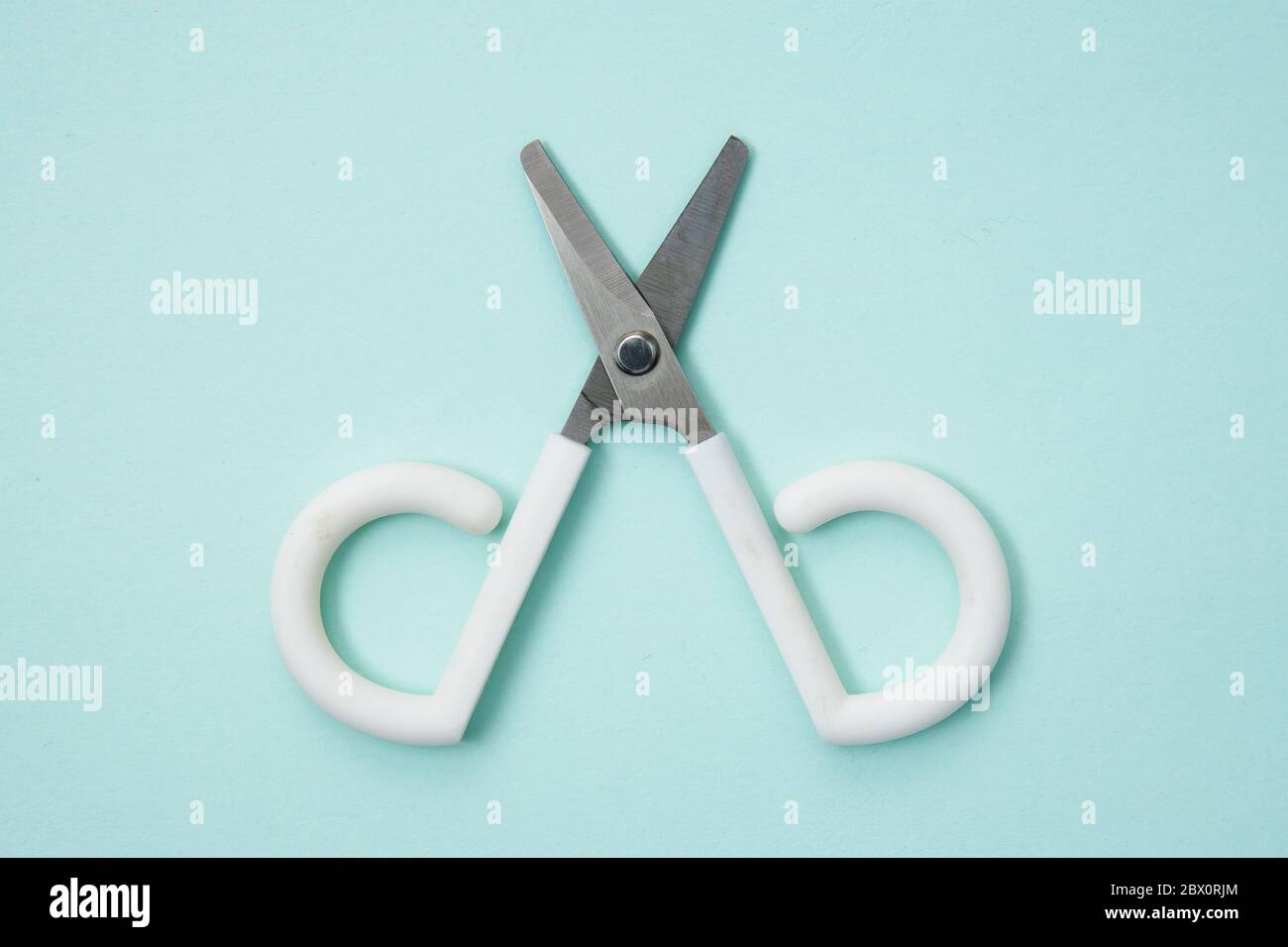 Little cute scissors on a light blue background Stock Photo - Alamy
