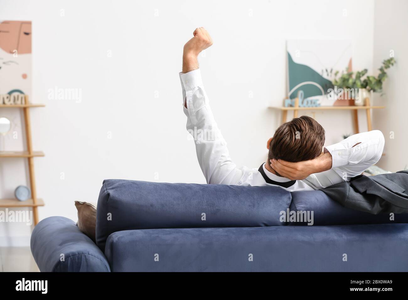 Businessman resting on sofa at home after long working day Stock Photo ...