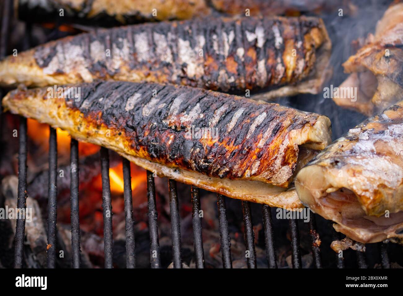 Grilled fish with smoke on a charcoal barbecue. Close up fish on the