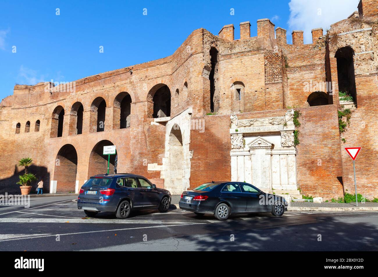 Rome, Italy - February 13, 2016: Rome street view with parked cars near old fortification walls of Porta Pinciana, it is a gate of the Aurelian Walls Stock Photo