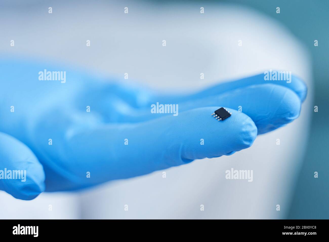 Hand holds chip compenent. Embedding the chip under human skin, microcontroller implanting NFC technology Stock Photo