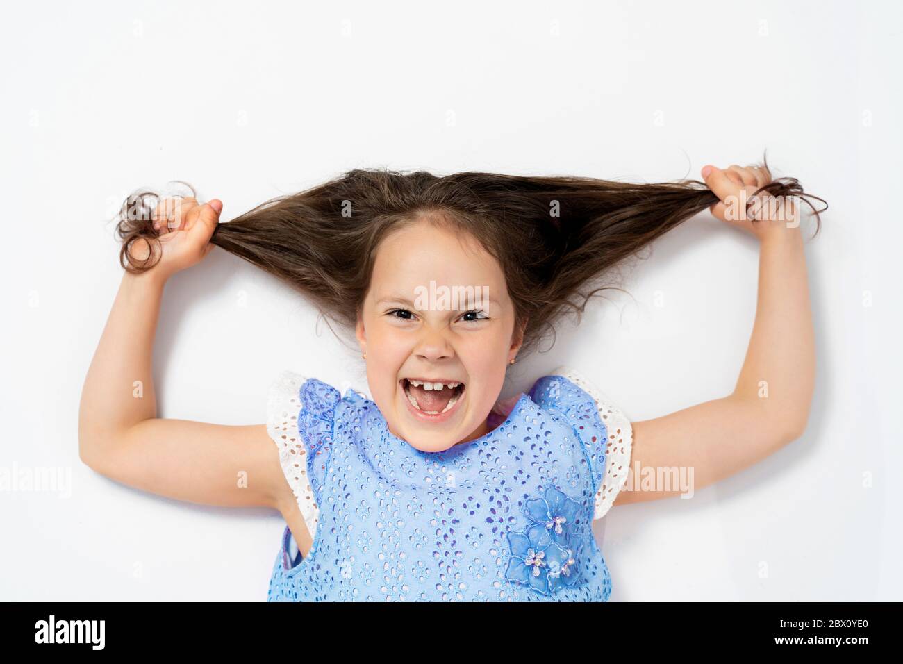 a beautiful girl lies on her back and pulls her hair to the side. the