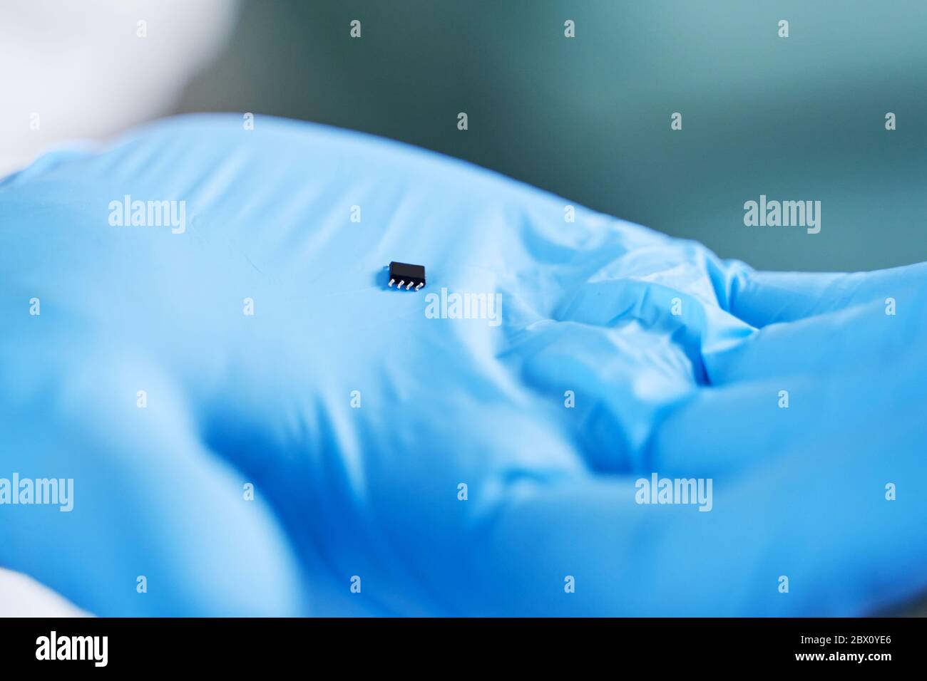 Hand holds chip compenent. Embedding the chip under human skin, microcontroller implanting NFC technology Stock Photo