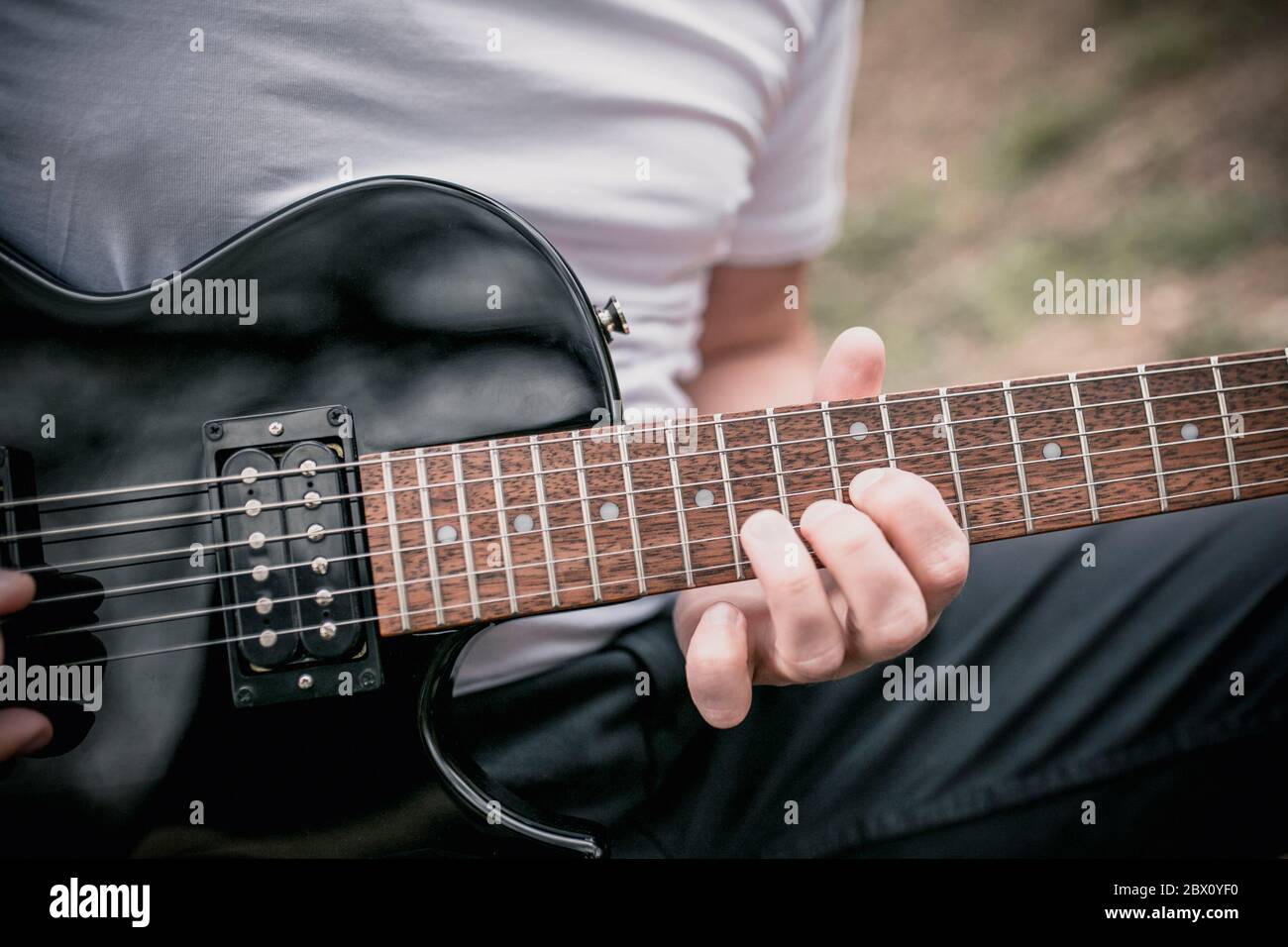 Technique of playing the electric guitar a man playing outdoors