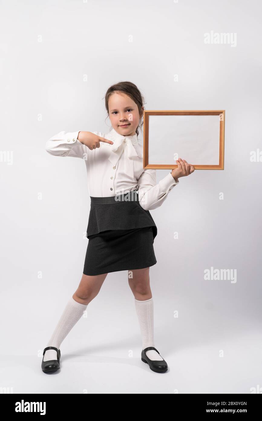 first grade school girl holds a white sheet for the inscription Stock Photo