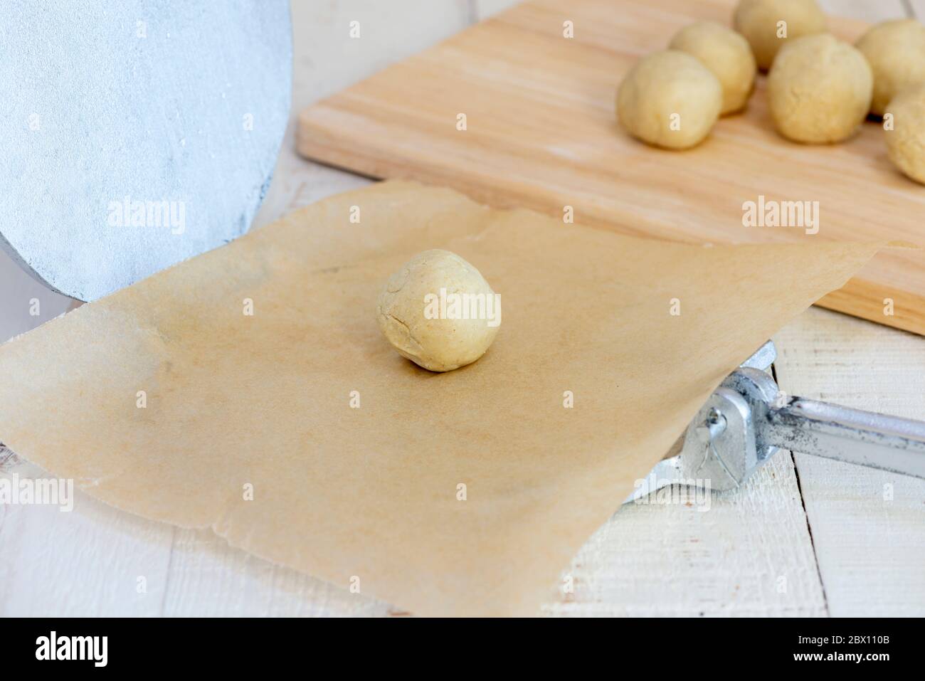 Making authentic corn tortillas - small ball of tortilla dough on tortilla press. Stock Photo