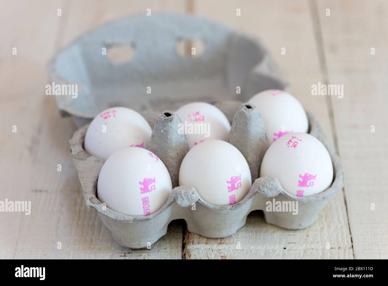 Six white shelled British Lion Standard eggs in a cardboard egg carton