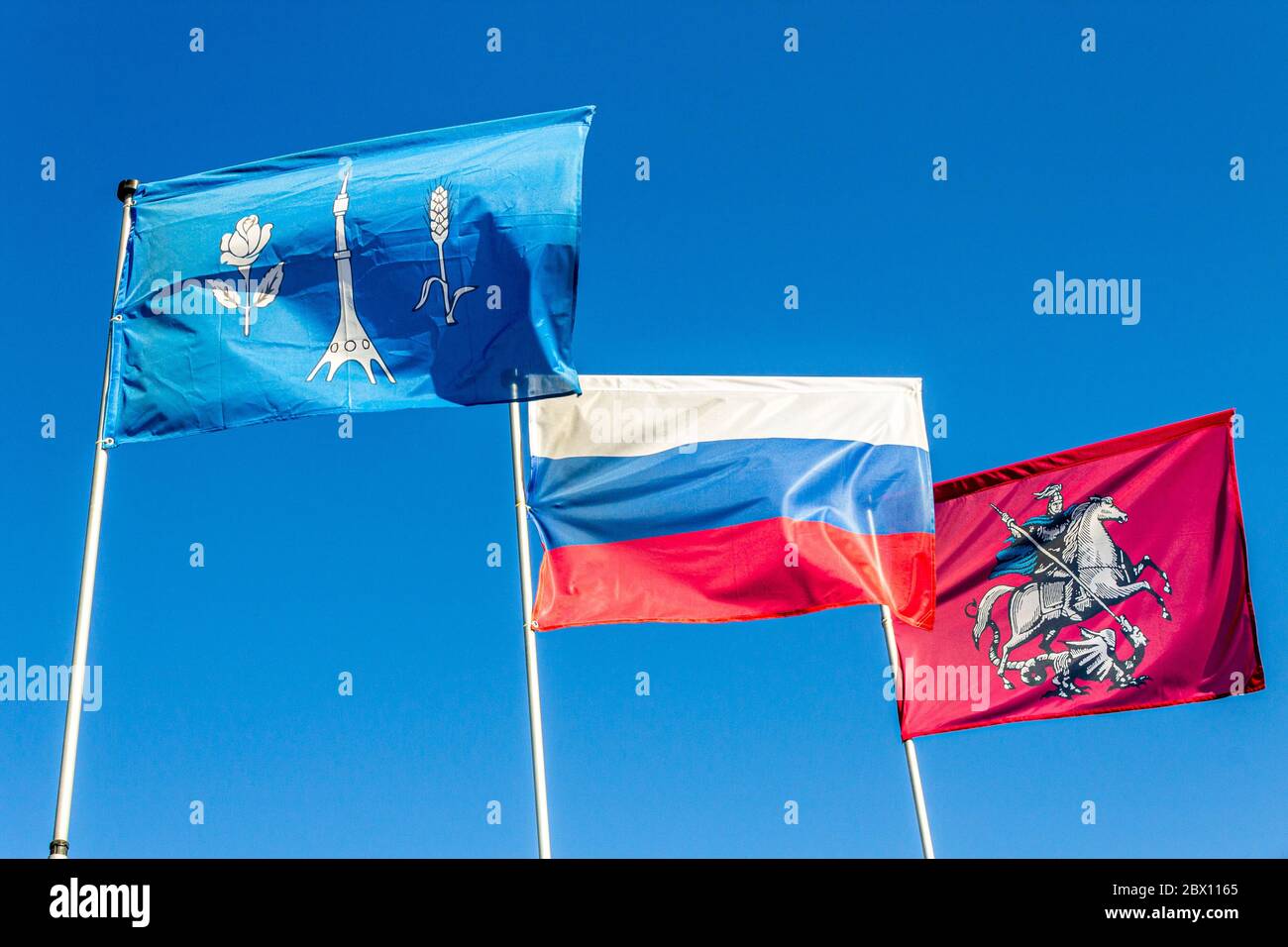 Blowing Flags of Rocket Monument to the Conquerors of Space, Russian Federation and Moscow City. Stock Photo