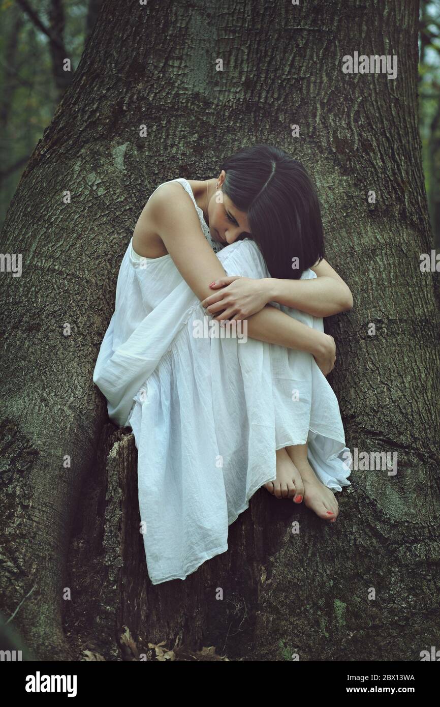 Sad woman in a forest. Loneliness and melancholy concept Stock Photo