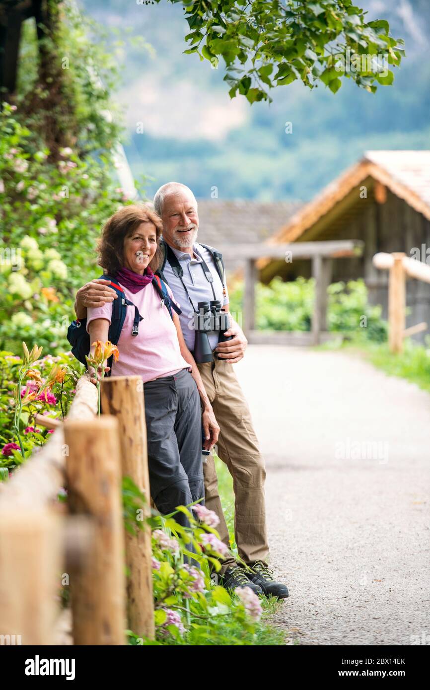 A senior pensioner couple with binoculars hiking, resting. Copy space. Stock Photo