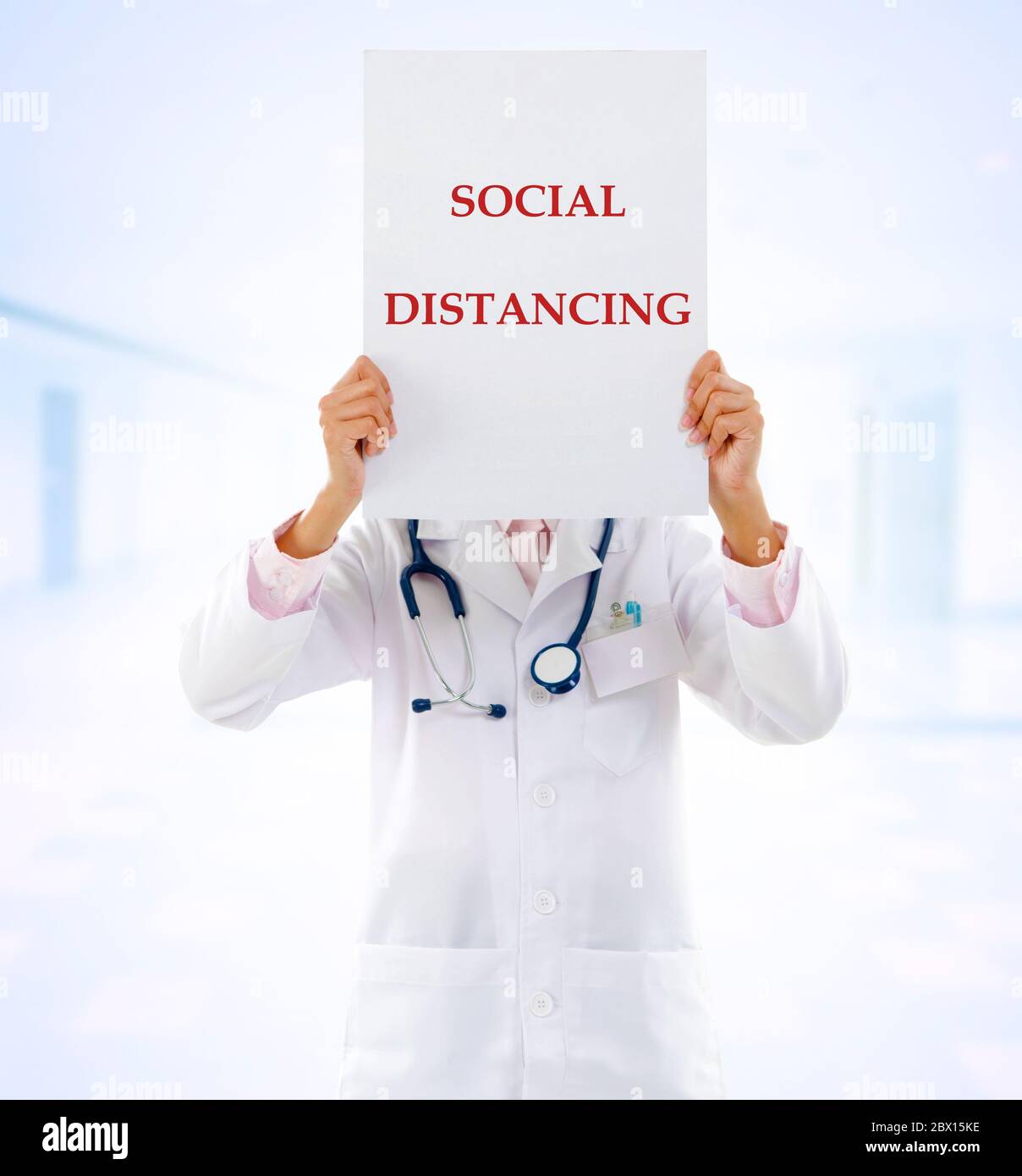 Medical doctor holding a card with social distancing on it. Stock Photo
