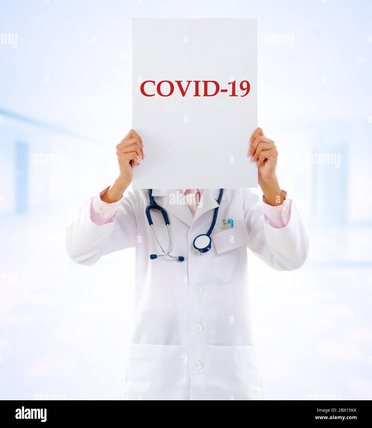 Medical staff holding a card with covid 19 on it. Stock Photo