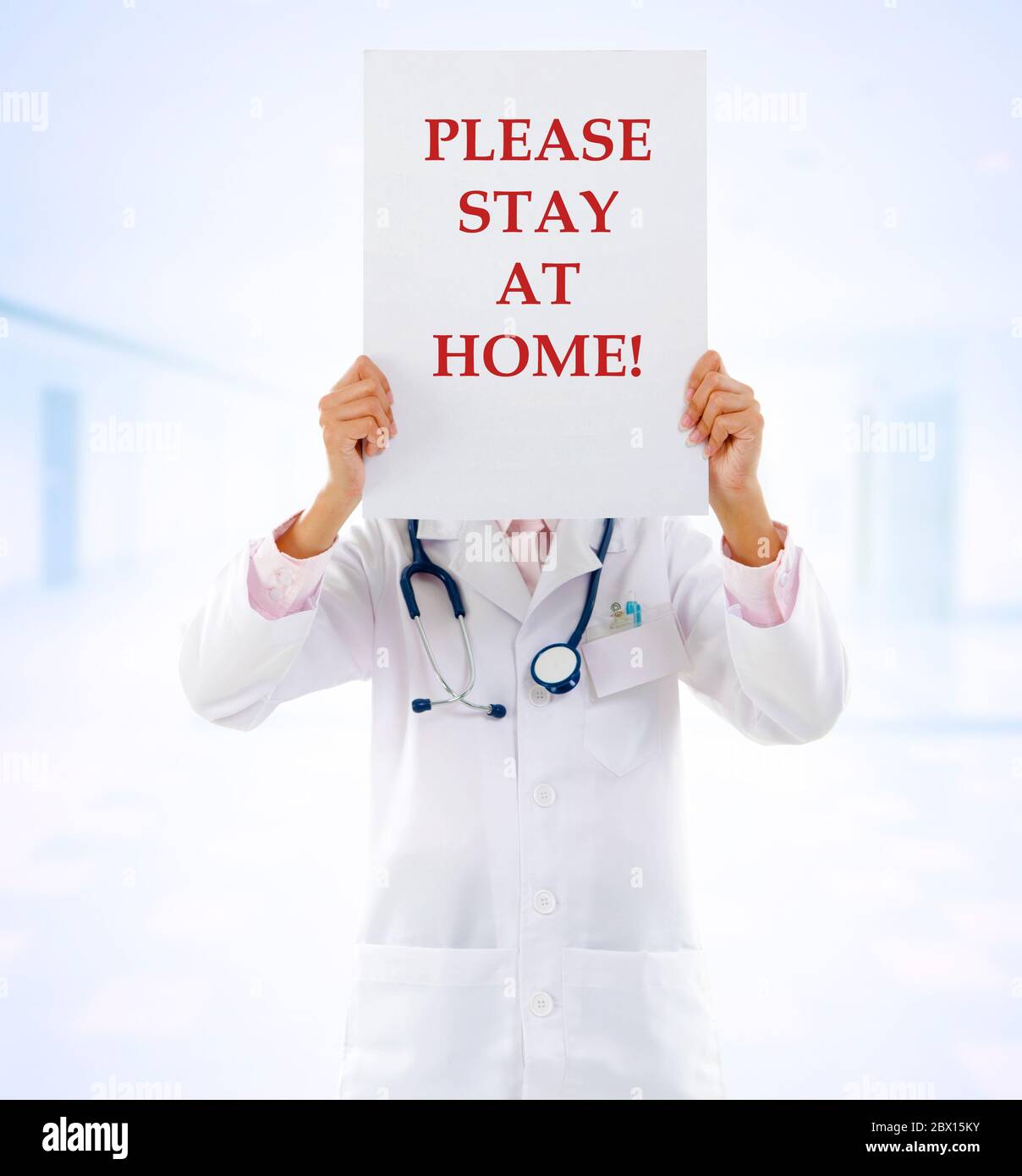 Medical staff holding a card with stay at home on it. Stock Photo