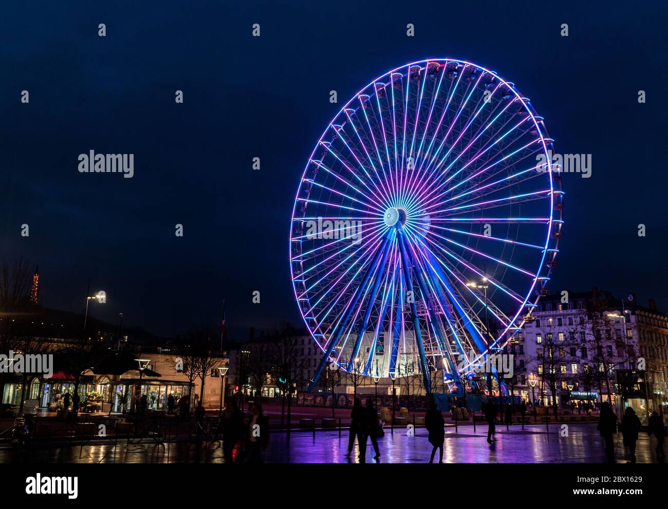 Lyon, France 3rd January 2020 - Ferris wheel at night on the Place Bellecour in the center of Lyon. Lit up by light in all coulors. Stock Photo