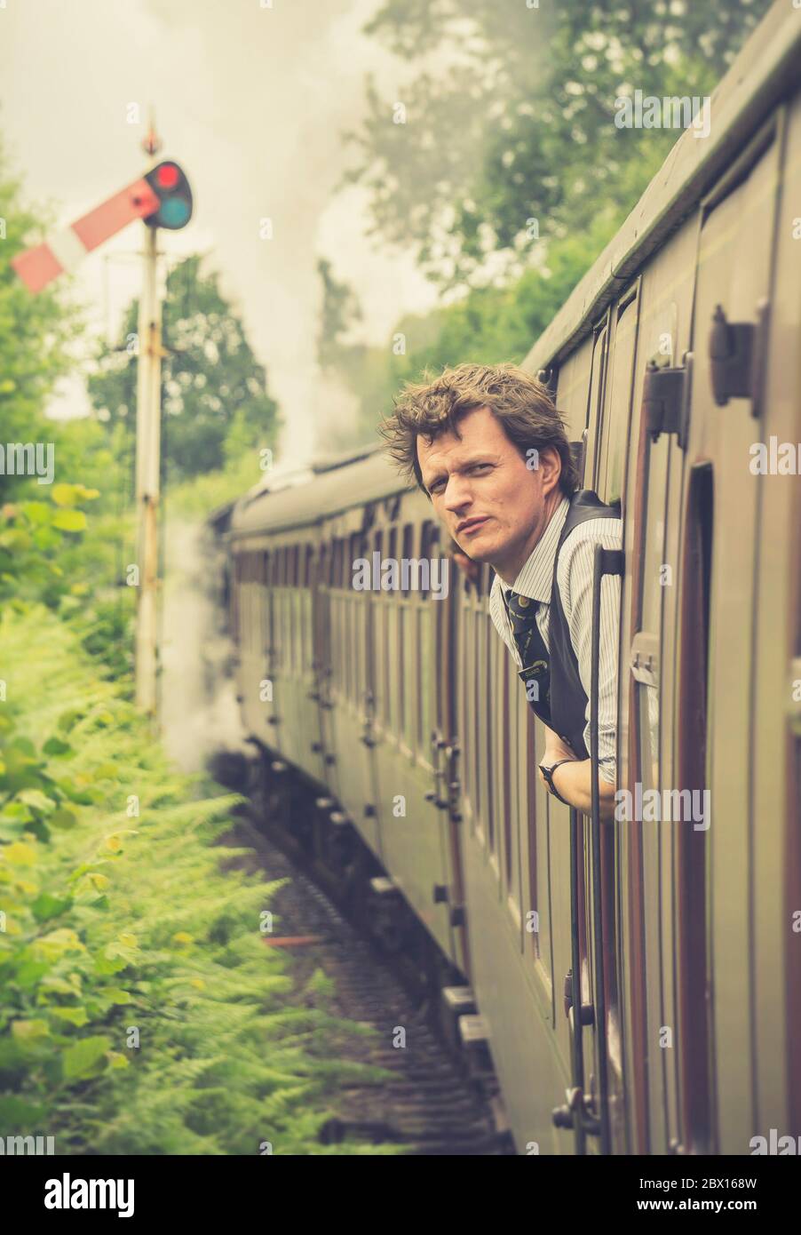 Young man looking out of train window on the historic steam engine