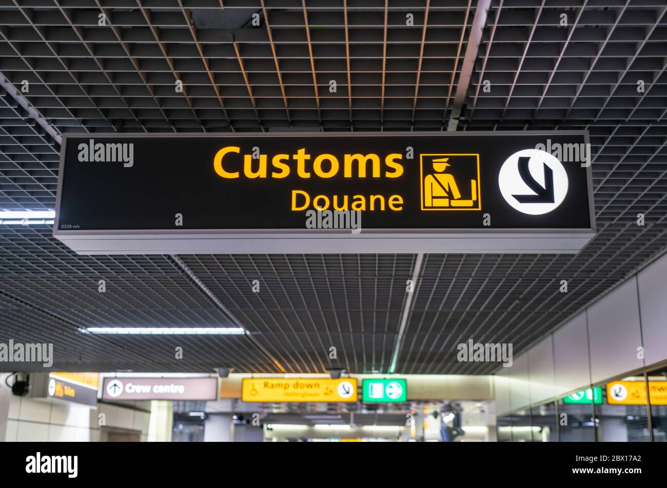 Customs sign at Schiphol international airport poiting passenergs to the customs area Stock Photo